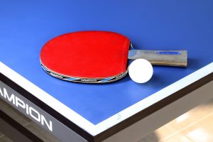 Tischtennisschläger mit Ball auf einem Tischtennistisch